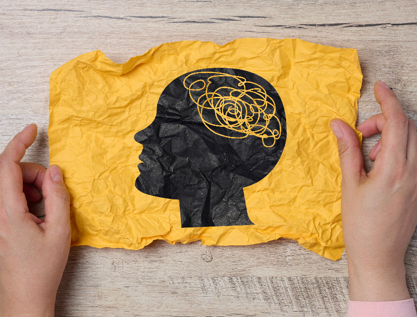 A female hand holds a crumpled paper with a black silhouette of Η ψυχική υγεία στον ΟΗΕ: ένα νέο παγκόσμιο αφήγημα και οι σκιές του